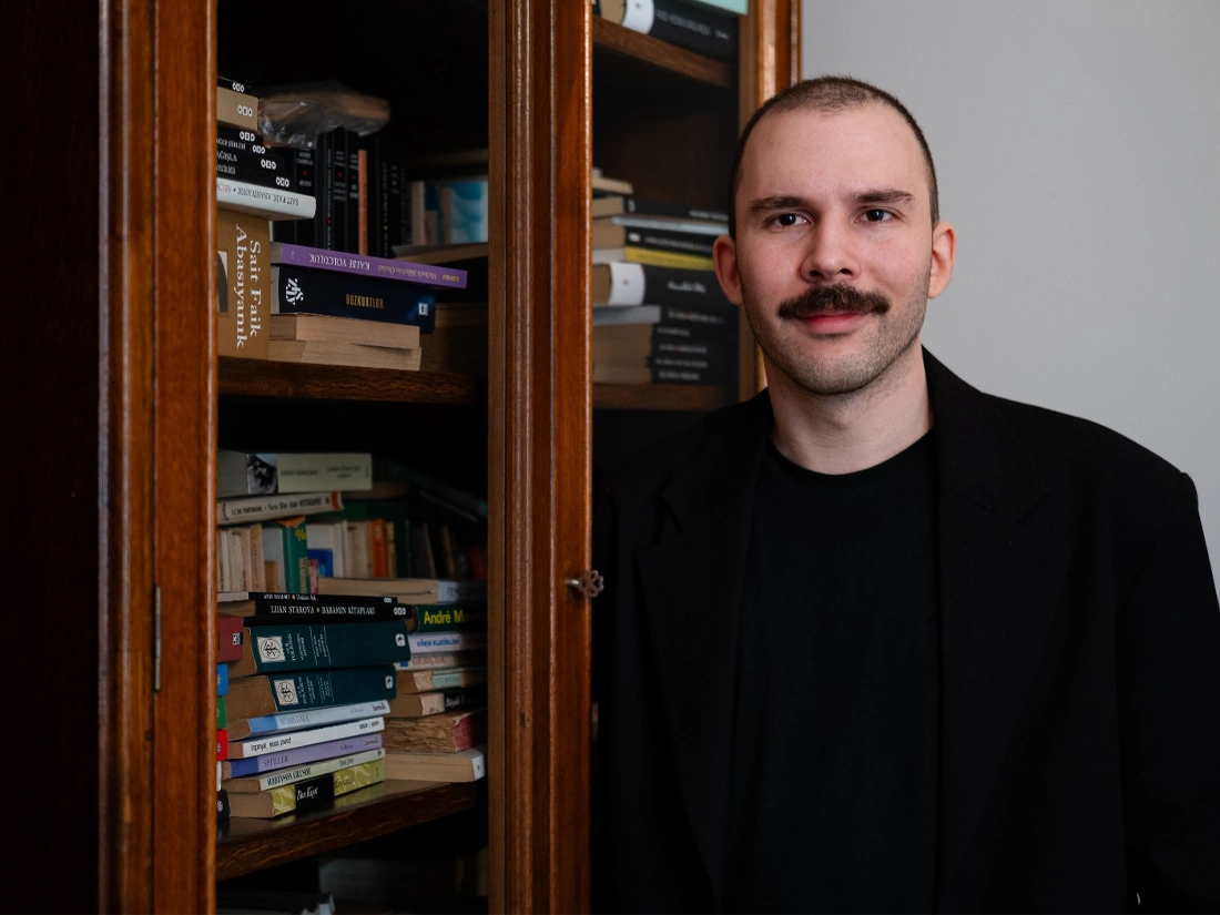 Uzman Klinik Psikolog Alp Deniz Domaniç'in ofisindeki kitaplığın hemen yanında durduğu bir fotoğraf